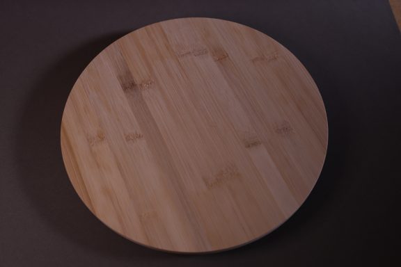 Plateau en bois rond de couleur claire, surface lisse et naturelle.